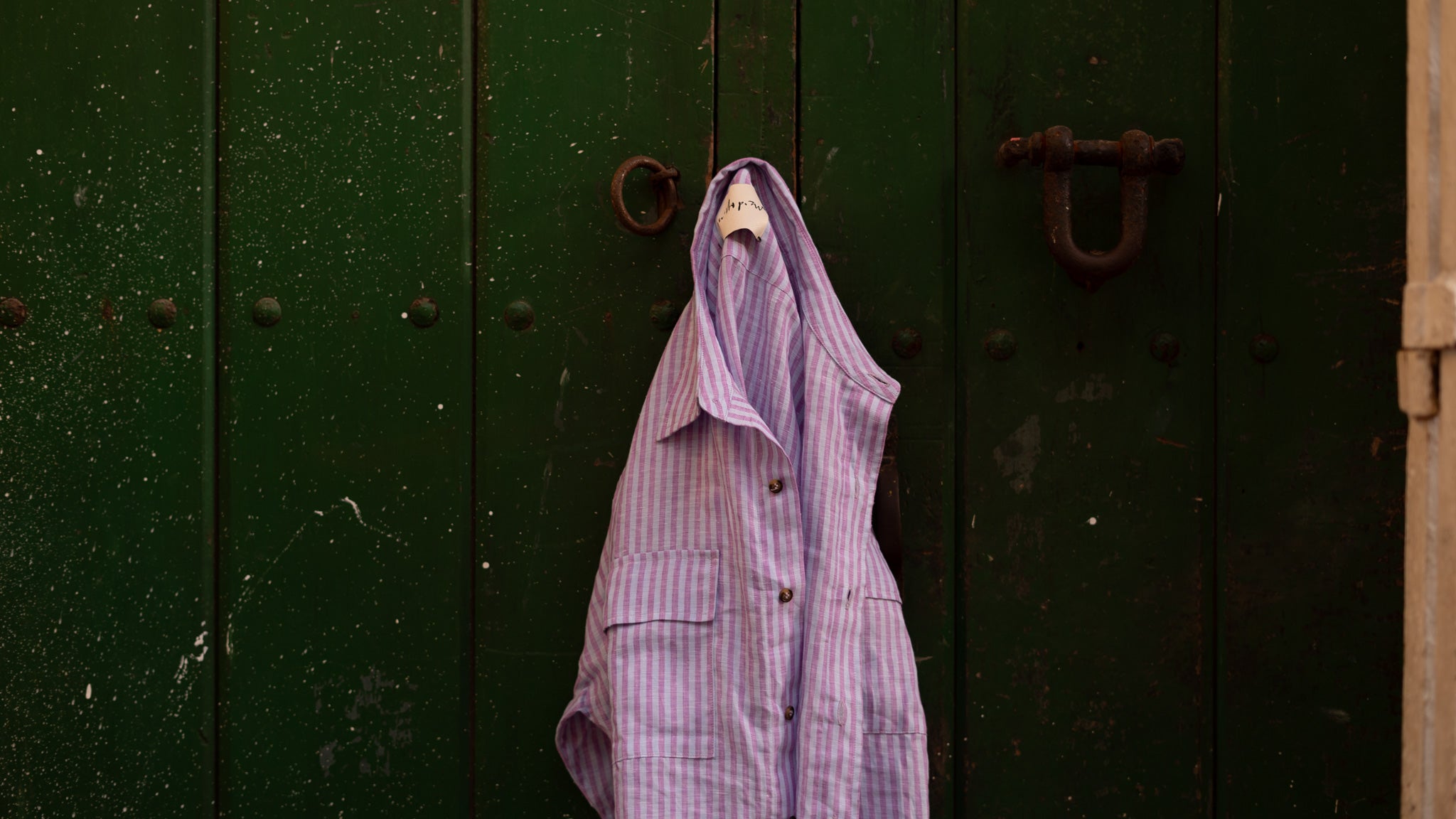 QUINTOPIANO DROPPED SHOULDER SHIRT PURPLE STRIPED HANGING IN LATIN COLONIAL DOOR