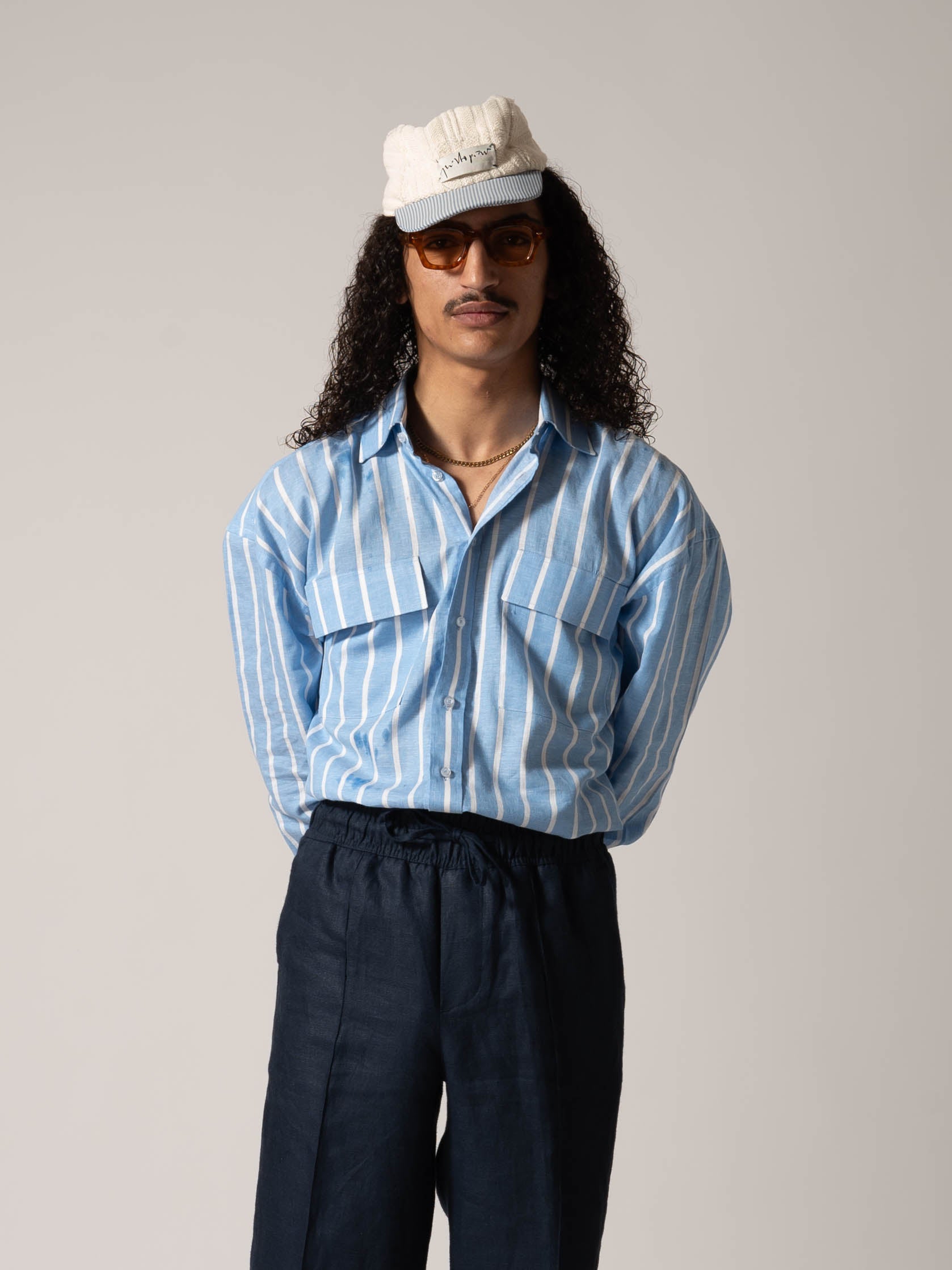 MODEL WEARING BLUE STRIPED COTON AND LINEN BLUE STRIPPED SHIRT